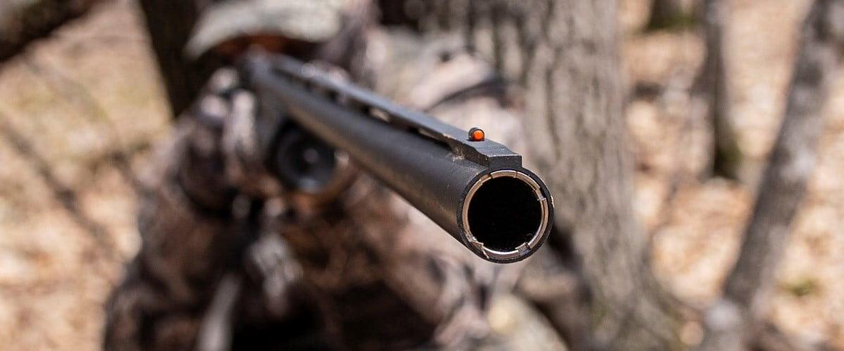 hunter looking down the iron sights of a shotgun