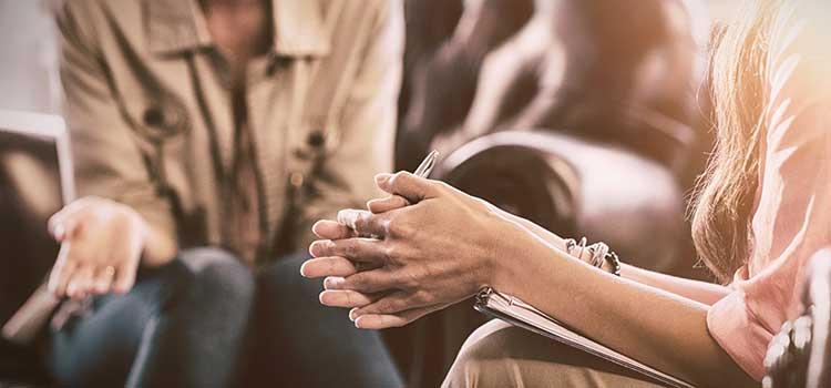 therapist hands with pen and client hands explaining issues